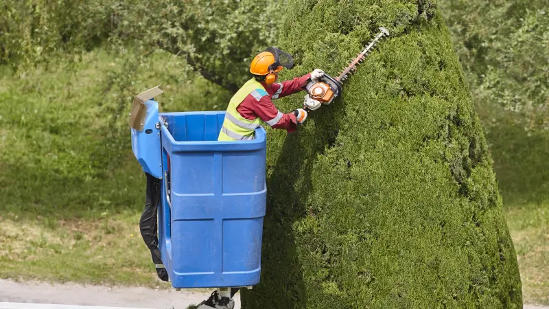 Operatore manutenzione del verde con DPI e tagliaerba