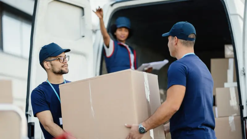 Operatori logistici che caricano scatoloni su un furgone