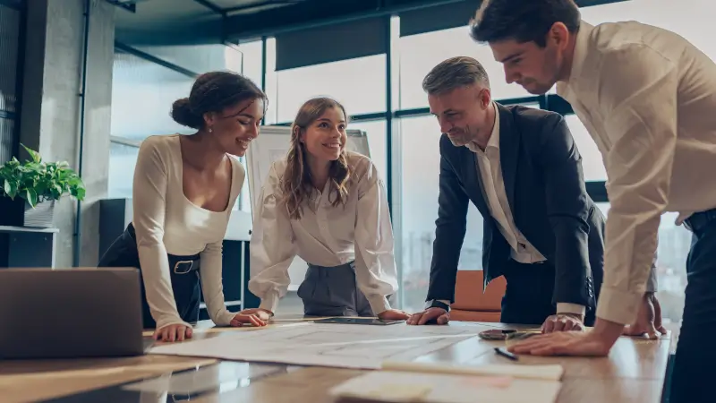 Riunione di lavoro in ufficio con analisi di un progetto sul tavolo